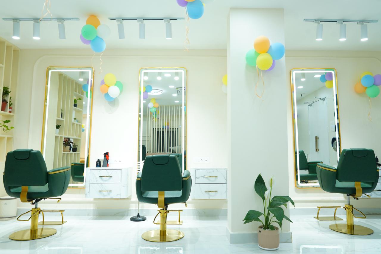 Styling stations with gold-lit mirrors and emerald velvet chairs