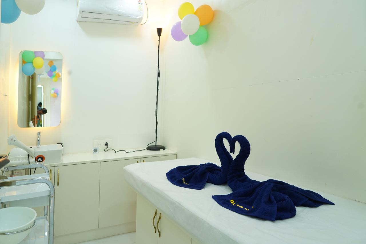 Alpa Salon spa room — white facial bed with navy towel swans