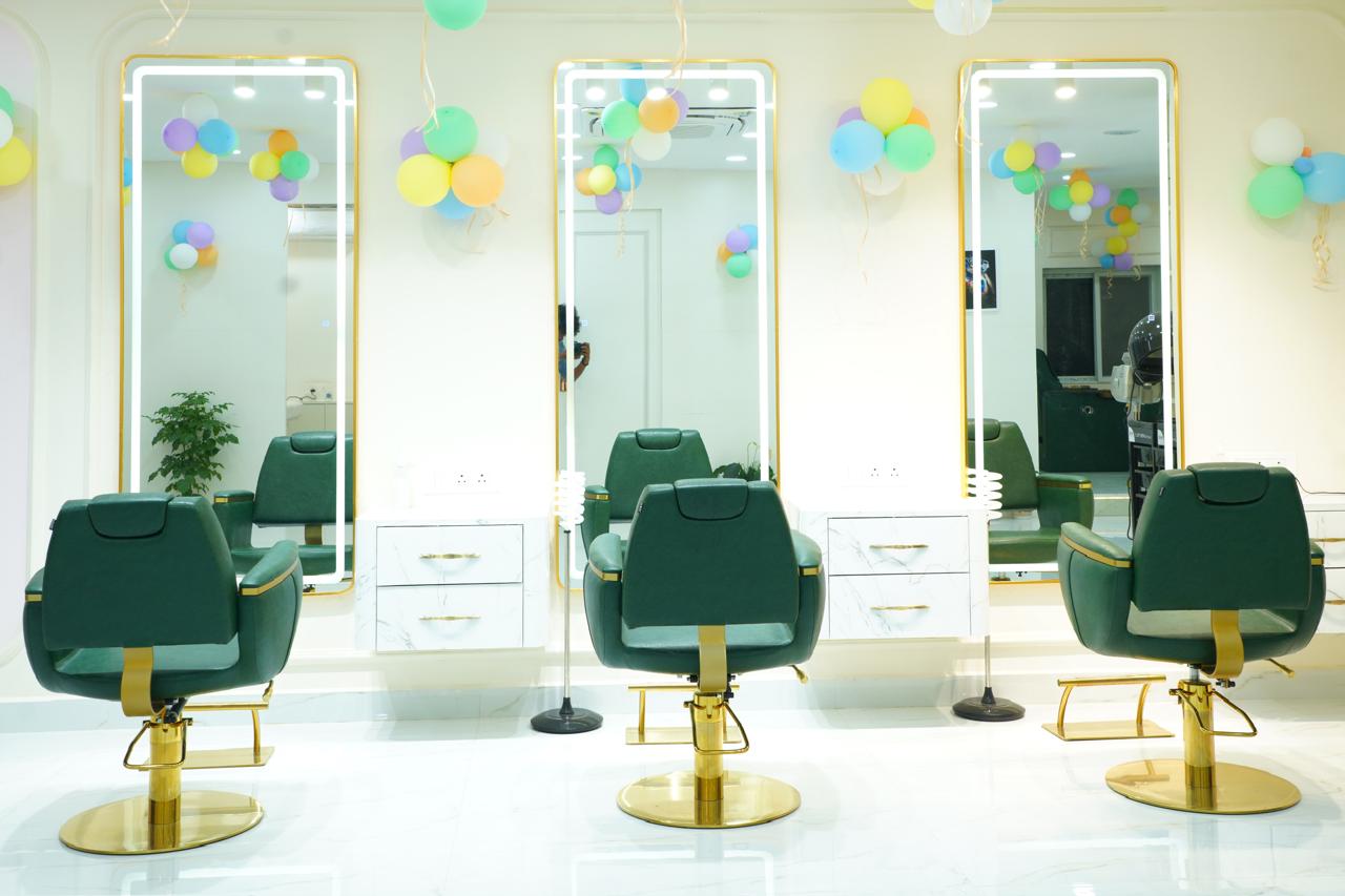 Row of gold-lit styling mirrors and emerald chairs at Alpa Salon